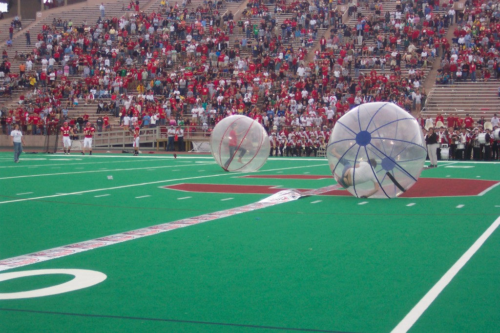 people rolling inside giant gerbil balls girl's thong showing